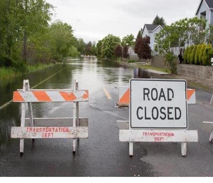 Flooded street with road closed sign