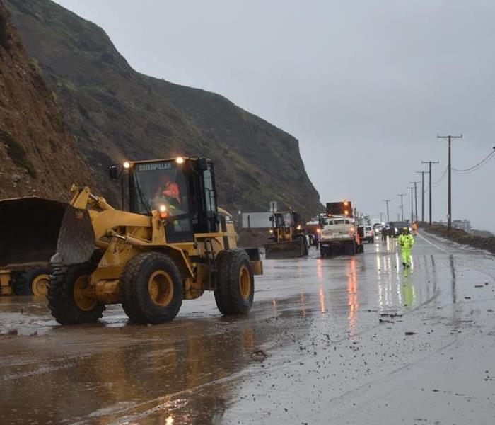 Road crews clearing the road after a flash flood